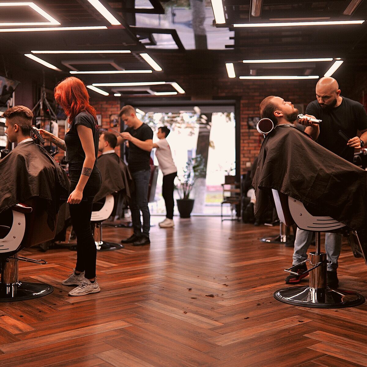 Ambiente de la barbería con clientes en atención